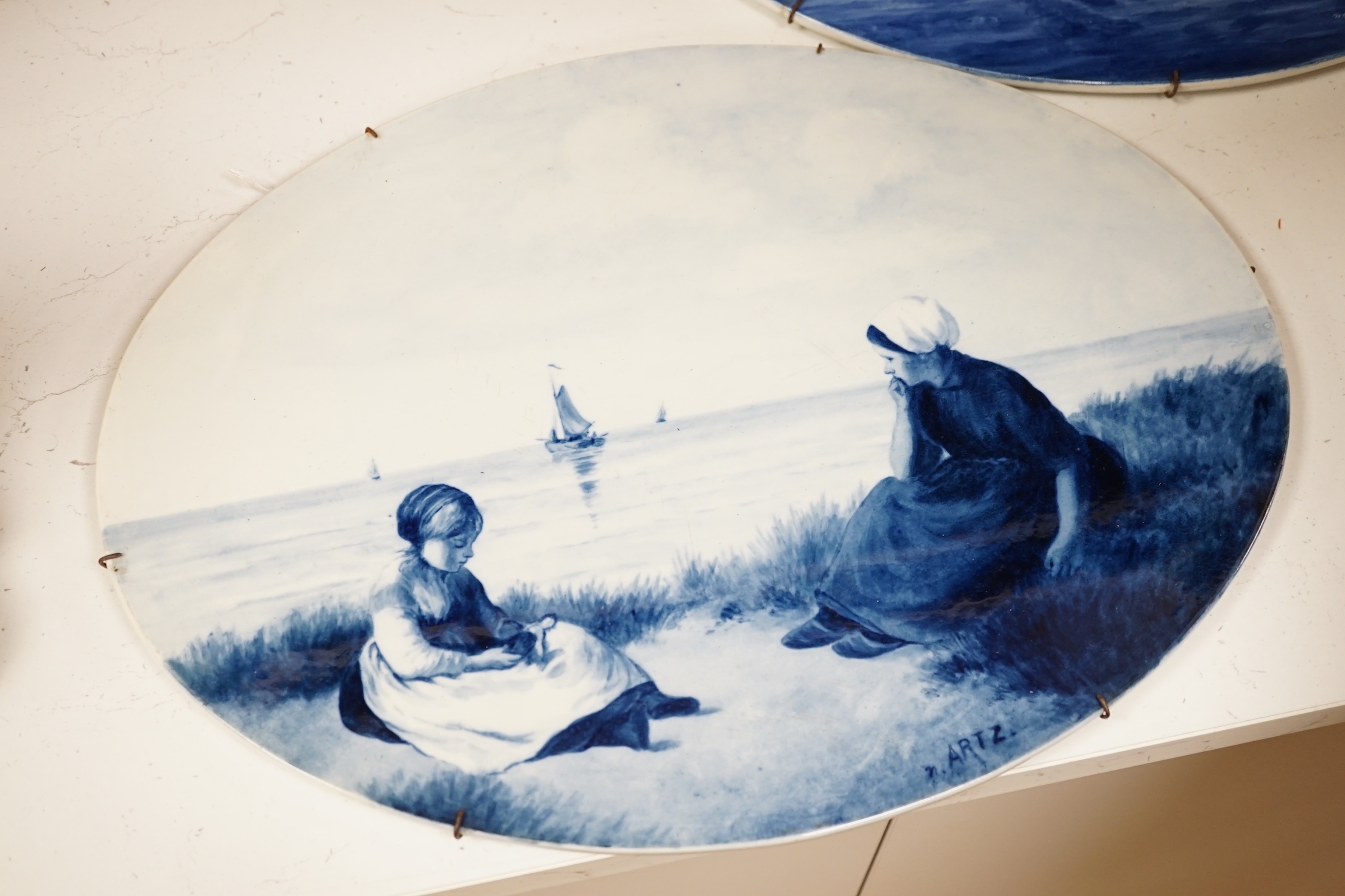 Three late 19th/early 20th century Delft oval landscape plaques, 45cm